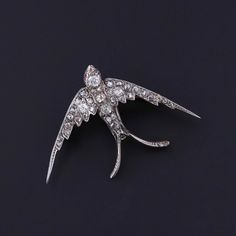 Antique Diamond Swallow Brooch: This antique swallow brooch dates to the late Victorian era (circa 1980).  The brooch is silver topped 14k gold and studded with old cut diamonds.  The piece measures 1.1 inches by 1.7 inches wide. It weighs 6.40 grams and is in great condition. Upon purchase, your brooch will arrive elegantly packaged, ready for gifting or as a special treat for yourself.  We carefully wrap each piece to ensure a delightful unboxing experience. We also offer free and flexible layaway plans, so take advantage of this option to make owning your dream piece even more achievable. + Trademark Antiques Shop Homepage https://www.etsy.com/shop/TrademarkAntiques + Our Store Policies https://www.etsy.com/shop/TrademarkAntiques/policy?ref=shopinfo_policies_leftnav + Connect with us on Antique Diamond Brooches As Gifts, Ornate Diamond Brooch As Gift, Antique Diamond Brooch For Gift, Swallow Bird Jewelry, Victorian Gold Diamond Brooches, Unboxing Experience, Silver Tops, Antique Diamond, Antique Shops