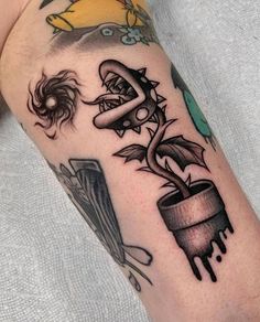 a tattoo on the arm of a man with an image of a plant in a pot