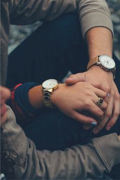 two people holding hands while sitting next to each other