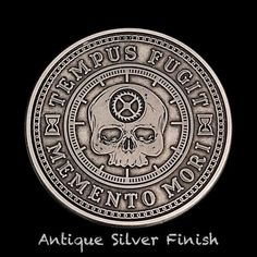 an antique silver finish coin with a skull on the front and side, in black background