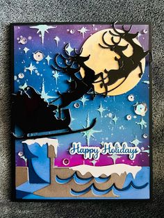 a handmade christmas card with a santa sleigh flying over the moon and stars