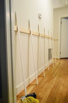 a hallway with several white poles on the wall and a yellow trash can in front of it