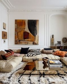 a living room filled with lots of furniture next to a painting on the wall and floor