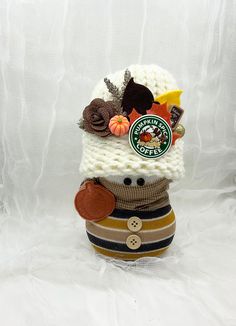 a stuffed animal wearing a knitted hat with buttons on it's head and scarf around its neck