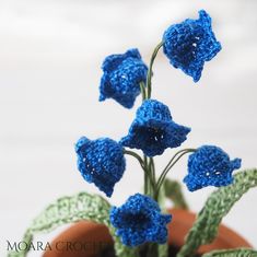 blue crocheted flowers in a clay pot