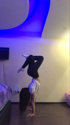 a woman is doing a handstand on the floor with her feet in the air