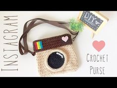 a crocheted camera purse with a chalkboard attached to it