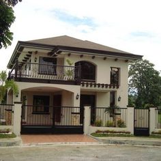 a white house with black railings and trees