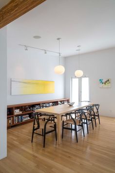 a dining room with wooden floors and white walls