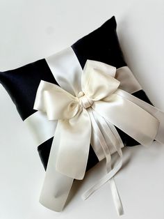 a black and white pillow with a bow on it