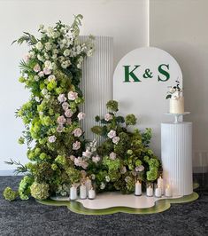 a table topped with flowers and candles next to a sign that says k & s