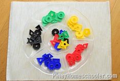 several different colored plastic buttons in a circle on top of a white cloth covered table