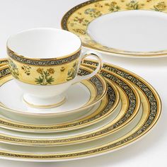 a white and gold china dinnerware set with flowers on the rims is shown