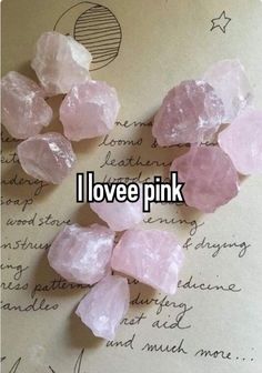 some pink crystals are on top of a piece of paper