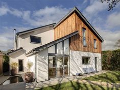 a modern house with large windows and wooden sidings on the side of the house