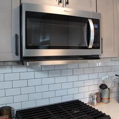 a stainless steel microwave oven mounted above a stove