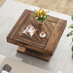 a coffee table with magazines and flowers on it