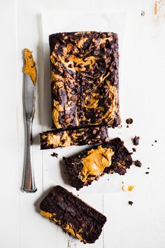 chocolate cake with peanut butter frosting and two slices cut out on a white surface