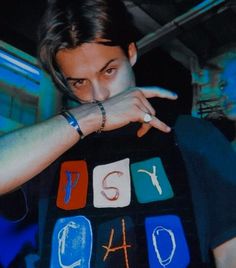 a man holding up a t - shirt with the word ps4 on it in front of his face