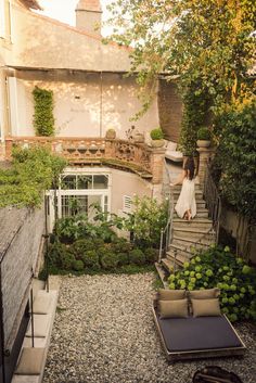 a woman is walking down the stairs in her backyard