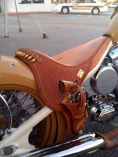 a brown horse saddle sitting on the back of a motorcycle