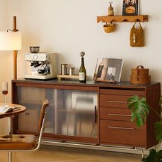 a room with a table, chair and wine glass on the sideboard in it