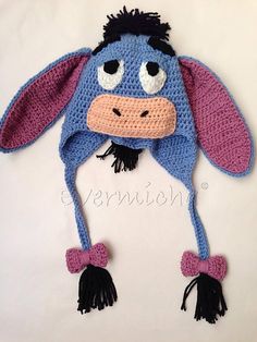 a crocheted blue and pink cow hat with black ears on it's head