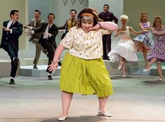 a group of people on stage with dancers in the background