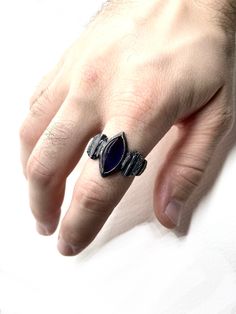 Crafted with the vision of capturing the essence of rings worn by ancient mages, this piece channels the very spirit of a bygone age. At its core, a deep, bewitching amethyst beckons with its rich and enigmatic purple hue. The Warlock's Amethyst Ring, a symbol of Gothic elegance and a testament to the arcane. Dare to make it yours, and let its dark magic weave its spell upon you. The sterling silver band, a canvas for craftsmanship that harks back to the primordial, is meticulously hand-carved a Fusion Style Amethyst Gemstone Rings, Amethyst Gemstone Fusion Rings, Mystical Gemstone Rings For Collectors, Handmade Mystical Amethyst Rings, Mystical Collectible Gemstone Rings, Mystical Amethyst Gemstone Rings, Gothic Silver Ring With Polished Finish, Mystical Sterling Silver Amethyst Ring, Luxury Handmade Sterling Silver Amethyst Ring