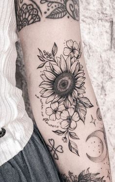 a woman's arm with a sunflower tattoo on it