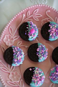 cookies decorated with sprinkles and chocolate on a pink plate