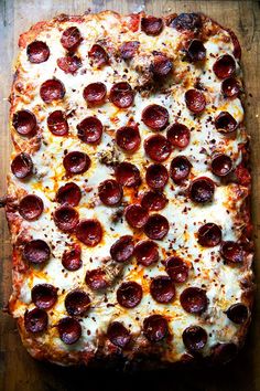 pepperoni and cheese pizza on a wooden cutting board, ready to be served in the oven