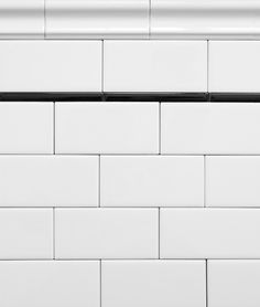 the corner of a white brick wall with black trim