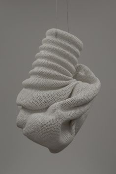 a white sculpture hanging from a string