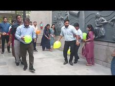 a group of people are playing frisbee in front of a wall with statues