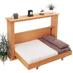 a wooden bed frame with two pillows on it and an air plant next to it