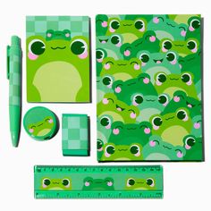 an assortment of stationery items including pencils, ruler and pen with frog faces on them