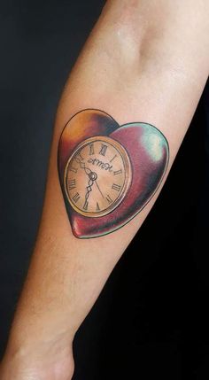 a heart shaped clock tattoo on the arm