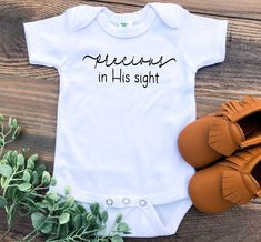 a baby bodysuit with the words peekins in his sight on it next to shoes