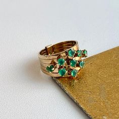 Estate/ vintage 14KT yellow gold round, imitation-emerald 5 Band Ring. A Mid-Century style design with multi-bands and multi-emeralds dispersed on each band. Size 4.25 Can be resized for an additional fee Fake emeralds measures: approx 2.75mm each (9) imitation emerald gemstones Approx. .95 carat deep, vibrant color emerald Some inclusions which is typical of am emeralds lab or otherwise and one is chipped. Weight: 3 grams 5 band design Excellent Estate Condition Clearly Antique Style Victorian Emerald Ring In 14k Yellow Gold, Victorian 14k Gold Emerald Ring, Elegant Multi-stone Emerald Ring In 14k Gold, 14k Gold Emerald Ring With 17 Jewels - Collectible, Vintage Multi-stone Emerald Ring In 14k Gold, Multi Band Ring, Band Design, Emerald Gemstone, Mid Century Style