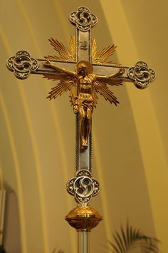 a golden cross on top of a metal pole