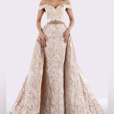 Get Ready To Turn Heads In This Stunning Feriani Ball Gown. The Ivory Colored Gown Features An Off-The-Shoulder Neckline And A Long Dress Length, Perfect For Any Formal Occasion. The Size 10 Gown Is Printed With A Champagne Design, Adding A Touch Of Elegance To Your Wardrobe. The Brand, Feriani, Is Known For Their Quality And Attention To Detail, Making This Gown A Must-Have For Any Fashion-Forward Woman. Whether You're Attending A Wedding Or A Fancy Dinner Party, This Gown Will Make You Feel Co Gown With Overskirt, Wedding Dress Overskirt, Lace Wedding Dress With Sleeves, Mother Of The Bride Gown, Off Shoulder Gown, Mob Dresses, Couture Candy, Lace Dress With Sleeves, Backless Wedding Dress