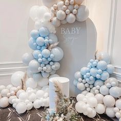 a baby shower is set up with blue and white balloons