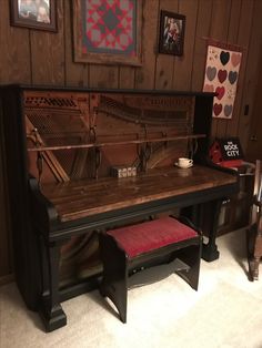 an old piano in a room with pictures on the wall