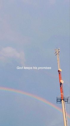 there is a rainbow in the sky and a radio tower with a quote on it