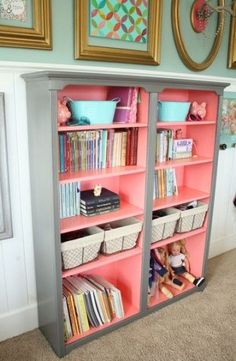 a pink bookcase filled with lots of books on top of a carpeted floor