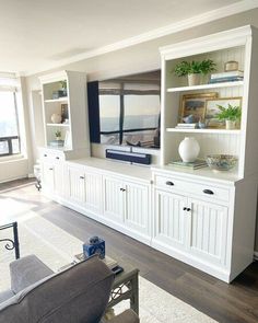 a living room filled with furniture and a flat screen tv on top of a white entertainment center