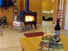 a living room with a fire place next to a table and wine glasses on the coffee table