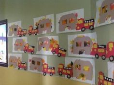 the wall is decorated with construction paper and cut out vehicles on it's sides