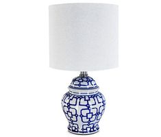 a blue and white vase lamp with a white shade on it's base, against a white background